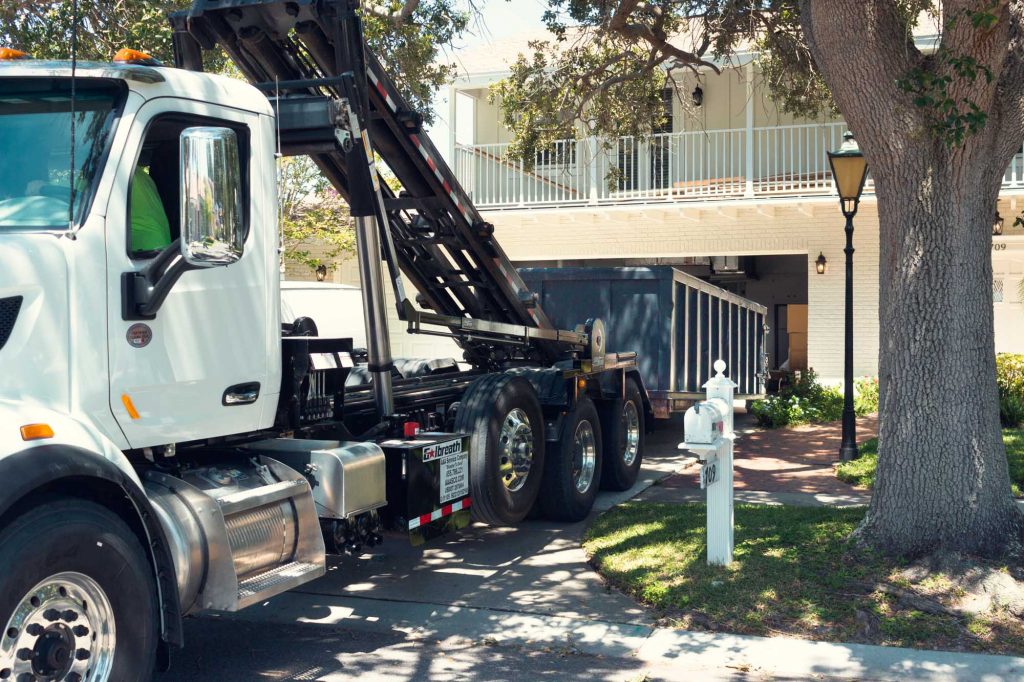 roll off dumpster being deposited at house