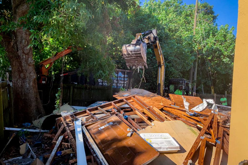 st petersburg residential demolition pod of houses excavator crushing walls as worker looks on